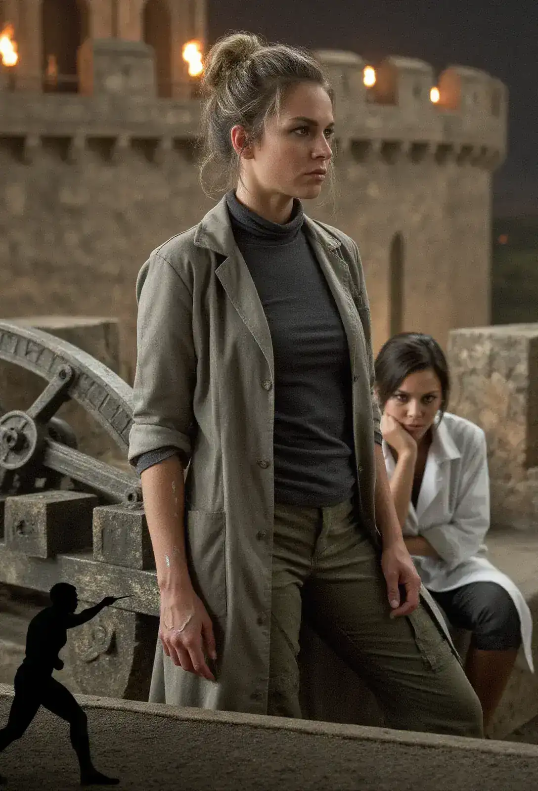 A torchlit medieval parapet at night, an ancient catapult silhouetted at the corner, a woman in a lab coat sitting at its base with her chin on her wrist.
